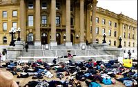 Protestors lay outside of the Alberta Legislature Building.