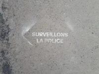 Spray paint on pavement that says surveillons la police.