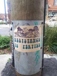 Un panneau en papier qui dit que la résistance est fertile sur un poteau téléphonique.