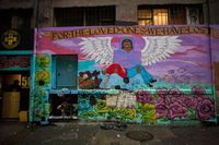 Graffiti covering the front of a building, including a graffiti banner that says "For the loved ones we have lost". &rdquo;