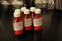 Six bottles of prescription Methadone are placed together on a tabletop.